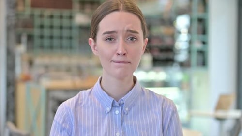 Sad Young Adult Woman Looking at Camera