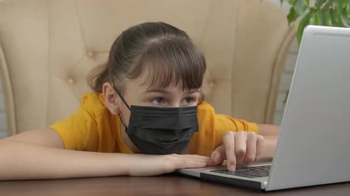 Child Wearing Mask Looking at Laptop Computer