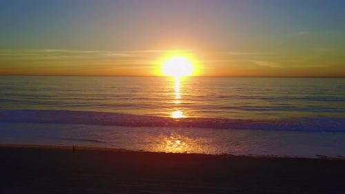 Aerial drone uav view of a sunset over the beach and ocean.