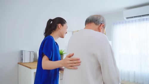 Caring Woman Helping Senior Man with Walker