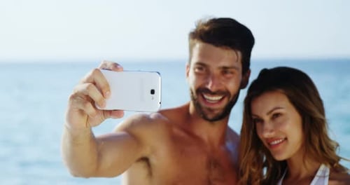 Couple taking selfie with mobile phone at beach 4k