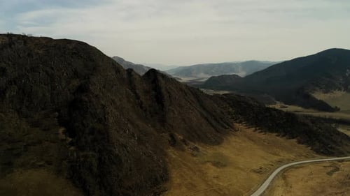 Large Mountains of Brown Color Against the Background of the Valley with Villages