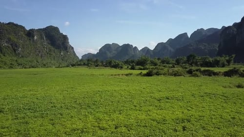 Close Motion Over Field To River in Valley Against Hills