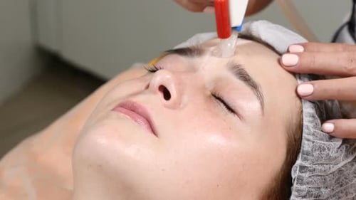 Woman Receives Facial with Beauty Device in Salon