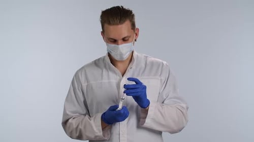 Young Adult Doctor Filling Syringe With Medicine