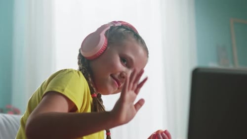 Child with Headphones Using Laptop at Home