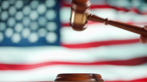 Um martelo de juiz com uma bandeira dos Estados Unidos da América em segundo plano