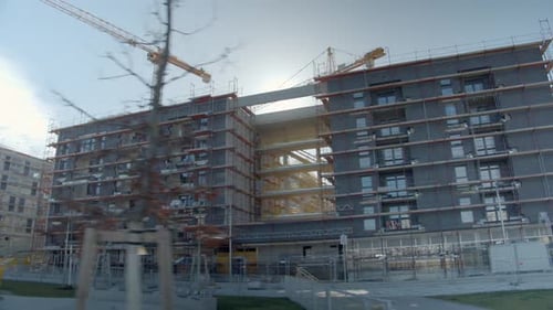 Exterior de edificios sin terminar con grúas torre en fondo. ángulo bajo, tiro de arco