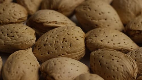 Cinematic, rotating shot of almonds on a white surface