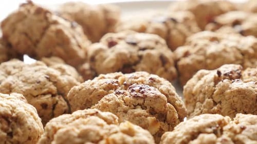 Homemade chocolate chip cookies on pile close-up 4K 2160p 30fps UHD tilting footage - Tasty biscuits