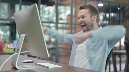 Un jeune homme excité célèbre le succès au travail