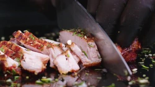 Close Up Shot of a Juicy Freshly Grilled Steak Straight From the Grid Being Cut with Fork and Knife