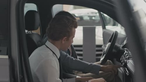 Car Salesman Demonstrates Vehicle Features to Customer