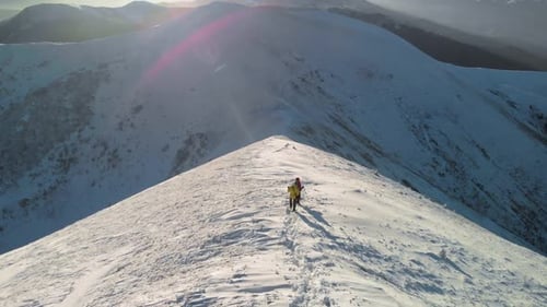 Couple of Hikers Moving on a Snow Covered Ridge