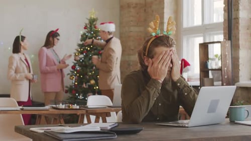 Tired Man Working in Office on Christmas Day