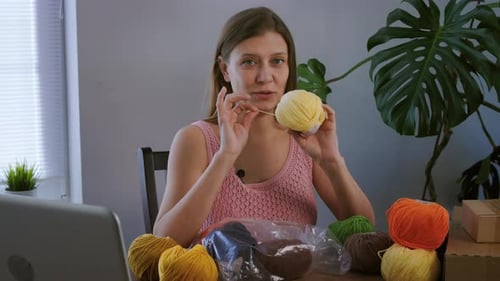 Woman Demonstrating Yarn Crafting at Home