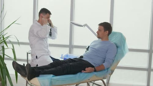 Doctor Measures High Low Blood Pressure of a Young Man in a Clinic Office