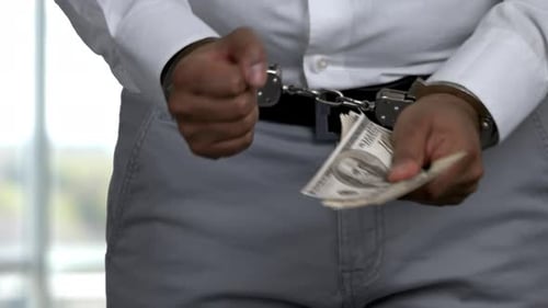 Person in Handcuffs Holding United States Dollar Bills