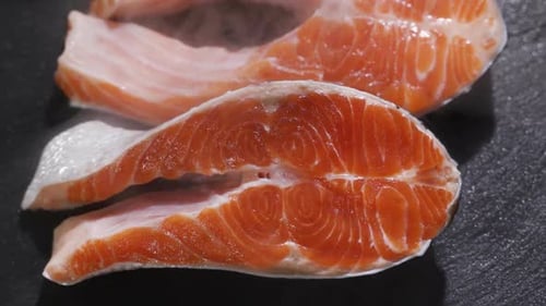 Preparation of Salmon Steak. Spice and Salt Sprinkled on a Raw Piece of Salmon