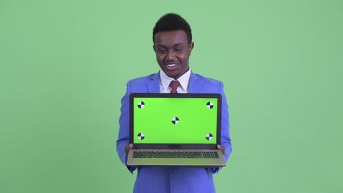 Smiling Businessman Holding Laptop with Green Screen