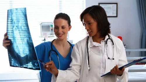 Medical Professionals Examining X-Ray in Hospital Room