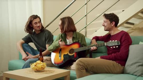Friends Enjoying Music, Guitar and Chips at Home