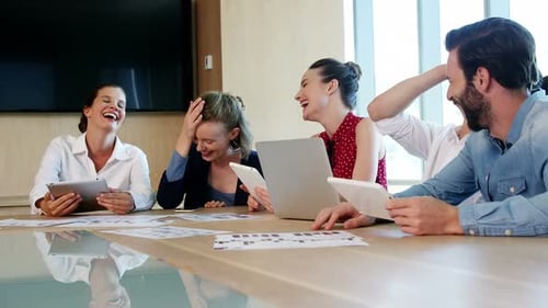 Coworkers Laughing Together in a Corporate Meeting