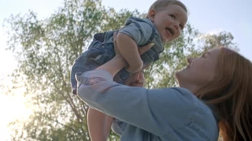 Mother Lifting Giggling Baby in Air