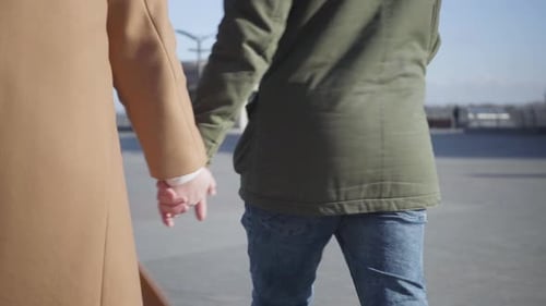 Young Couple Walking Hand-in-Hand in City