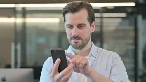 Reifer erwachsener Mann nutzt Smartphone beim Surfen im