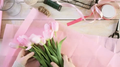 Arranging Fresh Tulips Bouquet on Wooden Surface