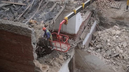 Construction Worker Demolishing Brick Wall with Jackhammer