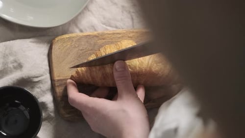 Top Down View of Woman Chef Cuts Croissant