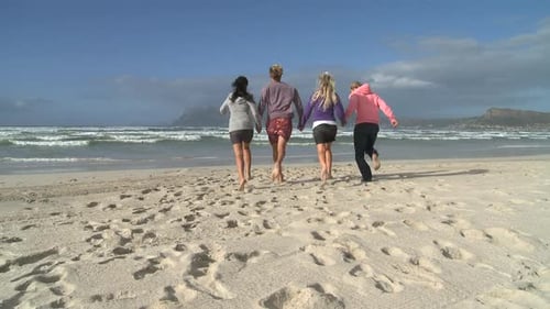 LS OF FRIENDS RUNNING ALONG A BEACH