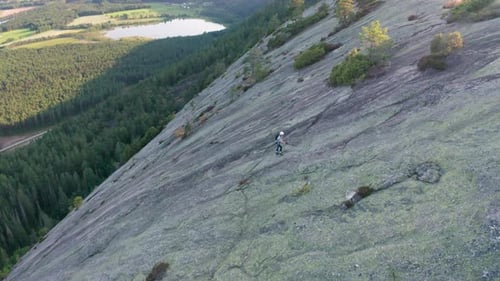 Drone Of Rock Climber Using Ropes To Climb Mountain Slope