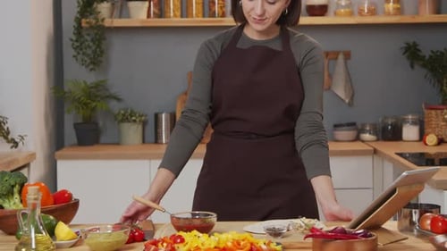 Woman Prepares Vegetables and Reads Recipe on Tablet