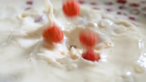 Raspberries Dropping Into White Liquid With Splash