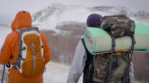 Hikers Trekking Across Snowy Mountain in Winter