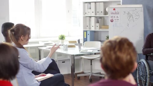 Senior Lecturer Presenting in a Wheelchair to Students