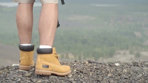 Man Puts Backpack on and Hikes Down Hill