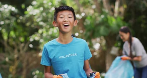 Child Volunteer Picking Up Trash in Park