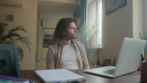 A Professional Creative Man is Sitting at His Desk in a Home Office He is Looking for a Solution