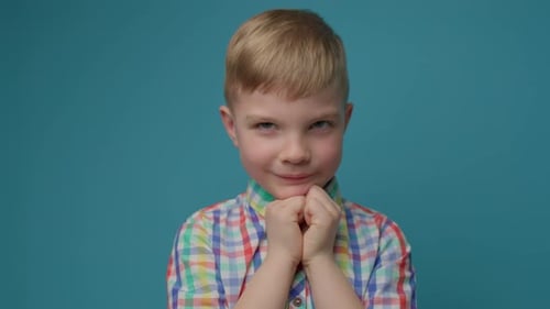 Fair-Haired Child Contemplates and Prays on Blue Background