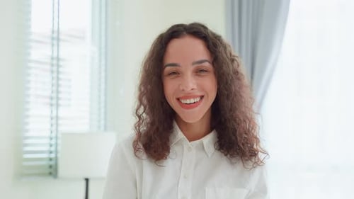 Smiling Woman with Curly Hair in Bright Home