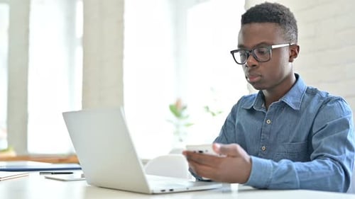 Young Adult Working on Laptop and Phone