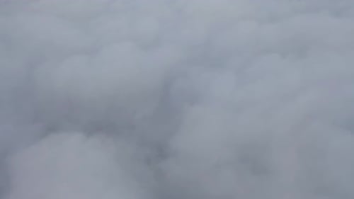 Aerial view of sunrise above fluffy sea fog misty clouds with mountain hill