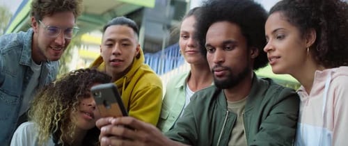 Enthusiastic Young Adults Looking at Cellphone Together
