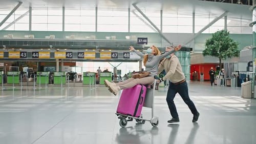 Woman Rides Luggage as Friend Pushes Through Airport