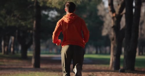 A Man Jogging Running in a Park Slow Motion Back View