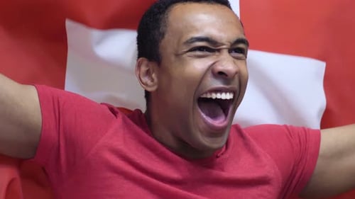 Excited Man Cheering with a Red and White Flag